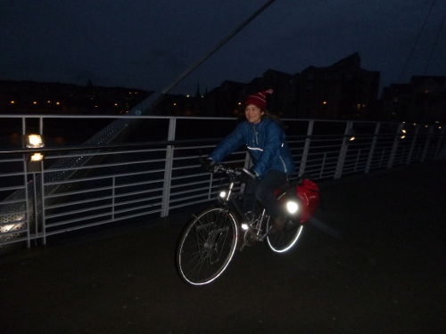Cyclist riding over a bridge at night.