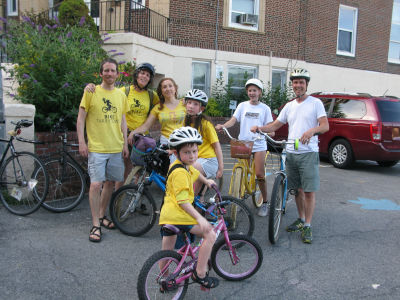 Photo of a group of people standing next to their bicycles.