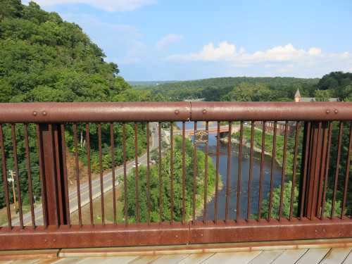 View of a valley, taken through the railing of a bridge.