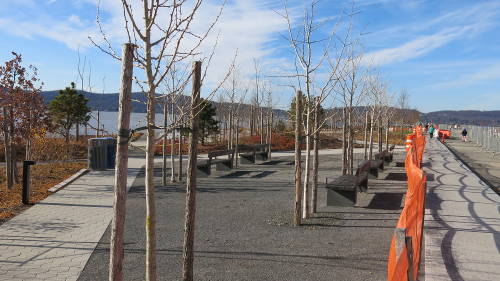 Photo of a riverfront park with construction fences around it.