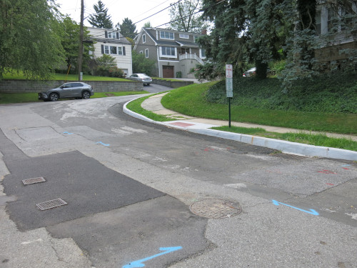 Photo of a residential street that has new curbs on the right side of it.