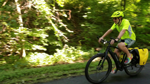 Person riding an ebike on a paved trail.