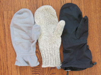 Photo of a fleece mitten, a slightly larger wool mitten, and a large nylon mitten cover.
